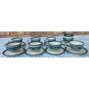 AN OFF WHITE WITH GREEN TRIM STONE WARE COFFEE CUP AND SUGAR BOWL SET SOLD AS IS